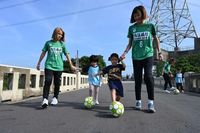 高雄陽信女足與茄拔國小附設幼兒園學童一同踢球。官方提供