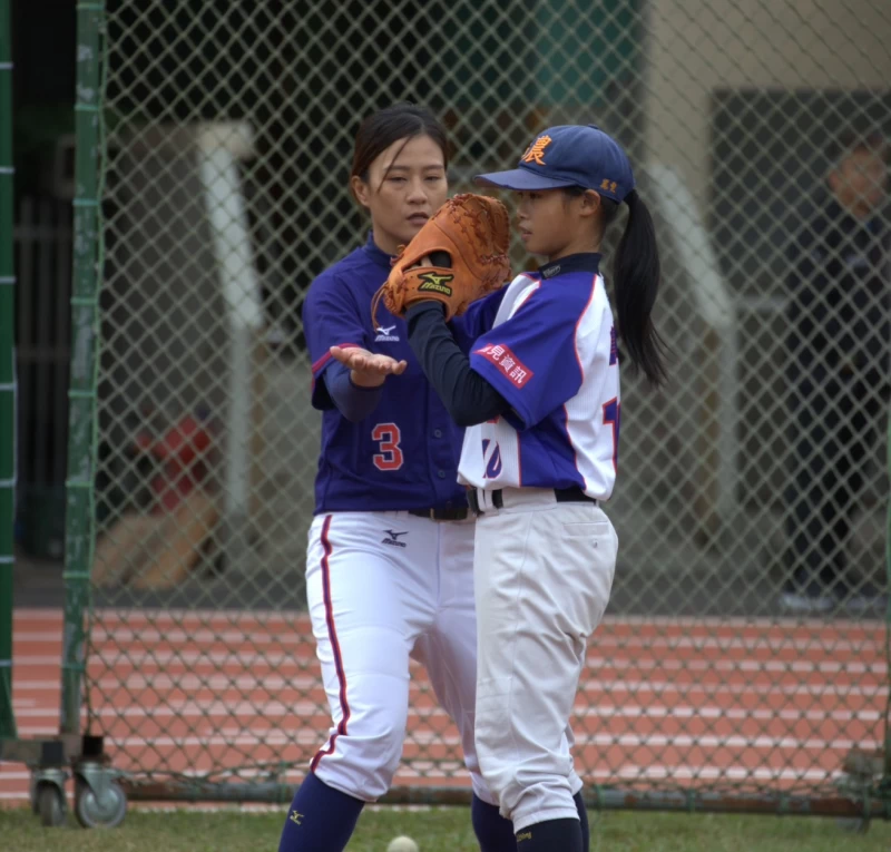 女棒國手黃巧芸細心指導立農國小女選手。官方提供