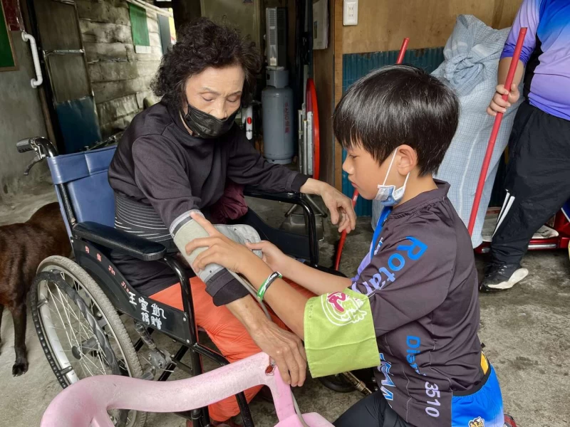 玉山國小學童獨輪車環島,樂扶基金會安排關懷阿美族老奶奶,幫忙量血壓按摩打掃居家環境。官方提供