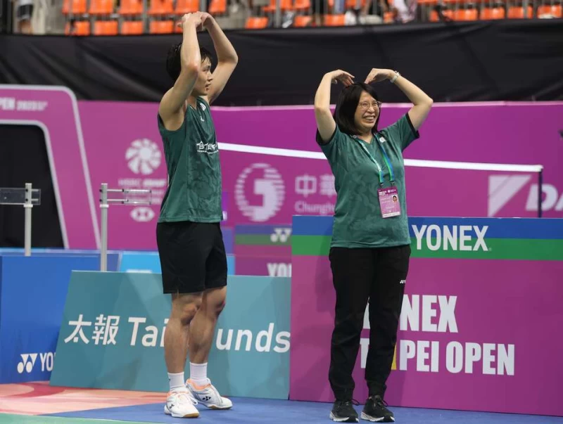 周天成獲勝後與教練一同向球迷比出愛心。李天助攝