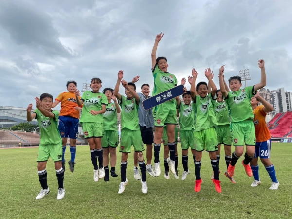 新北樂活鷹隊戰勝宿敵開心跳躍歡呼,台灣旅西職業足球員袁永誠(中)與小學弟們合照。大會提供