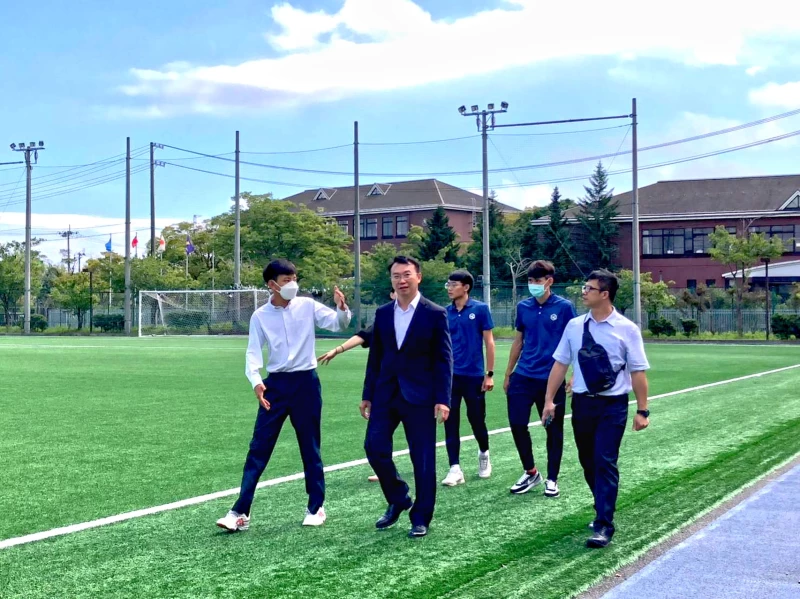 高雄市旅日田徑好手簡子傑(左1)向運發局參訪團介紹仙台育英高校運動訓練設施及場地。高雄市運發局提供