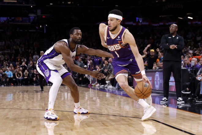布克(右)決勝時刻連投帶罰砍10分,護住太陽的戰果。法新社
