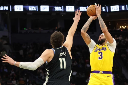 戴維斯(右)帶傷領湖人奮戰到2OT,最終以128-124擊敗公鹿。法新社