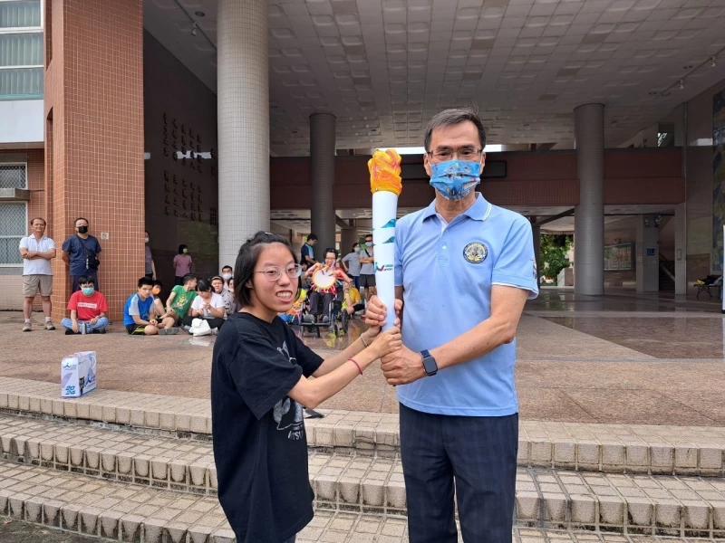 高雄市楠梓特校校長黃國書（右）、特奧保齡球項目吳妍鎂選手迎接聖火。高雄市運發局提供