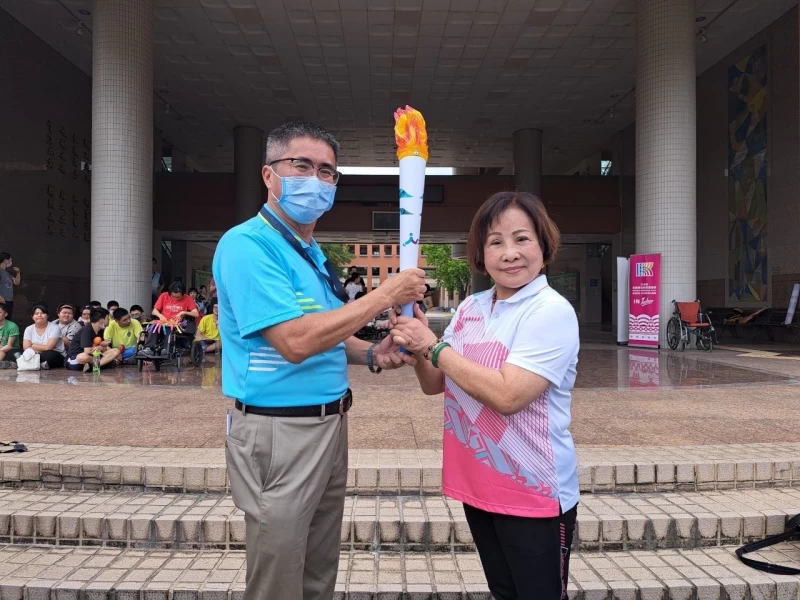 發局副局長謝汀嵩（左）由南投縣教育處督學鍾美月手中接過聖火。 運動發展局提供