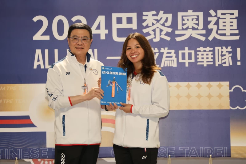 行政院卓榮泰院長(左)在選手啟程前往巴黎奧運前，致贈臺灣藍鵲意象禮品予教練及選手由游泳選手韓安齊代表接受。體育署提供