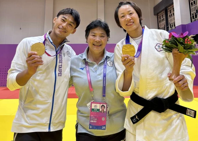 許淑慧教師中與杭州亞運柔道雙金楊勇緯(左)及連珍羚(右)合影。體育署提供
