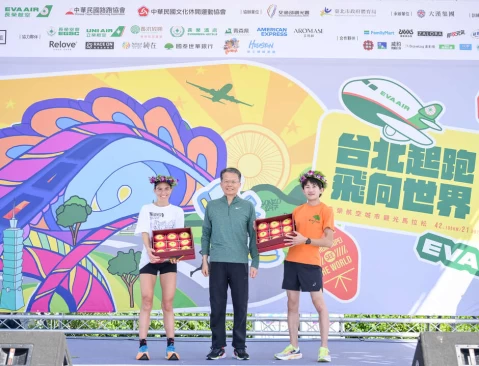長榮航空孫嘉明總經理(中)頒發青森縣廳空運來台的青森蘋果給全程馬拉松男子組冠軍日本鈴木智。大會提供