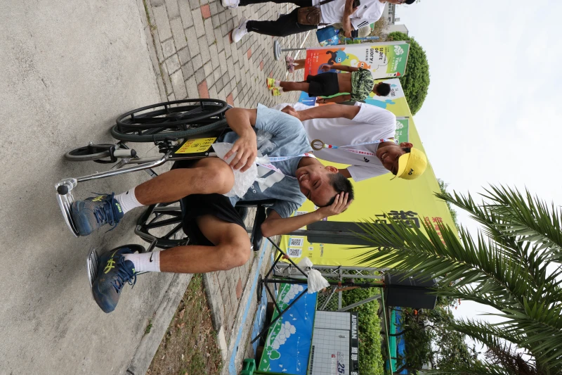 網球國男金牌決賽鏖戰3個多小時，金牌選手新興國中黃韋博後推著賽後抽筋的銀牌選手陳宏軒領獎。大會提供