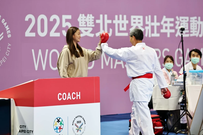 文姿云（左）賽後與選手趙志才擊掌打氣，大會提供