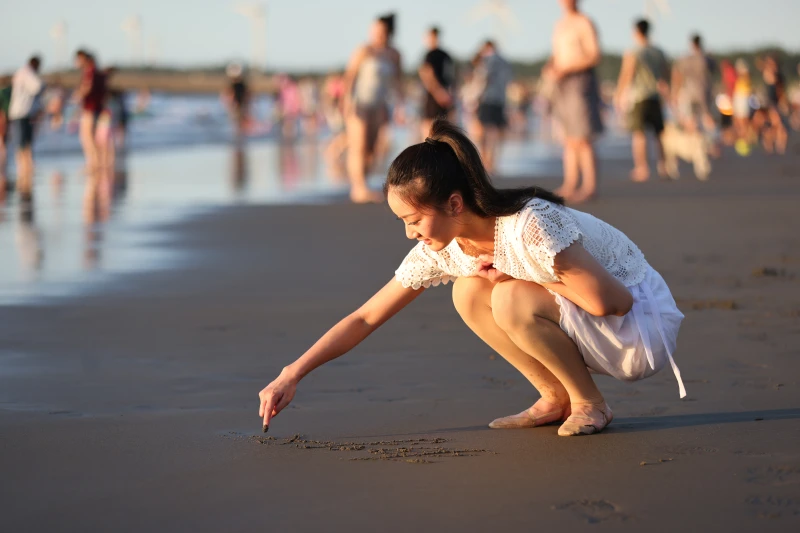 難得到海邊玩耍，喬伊在沙灘上寫下心願。特約記者/郭運復攝