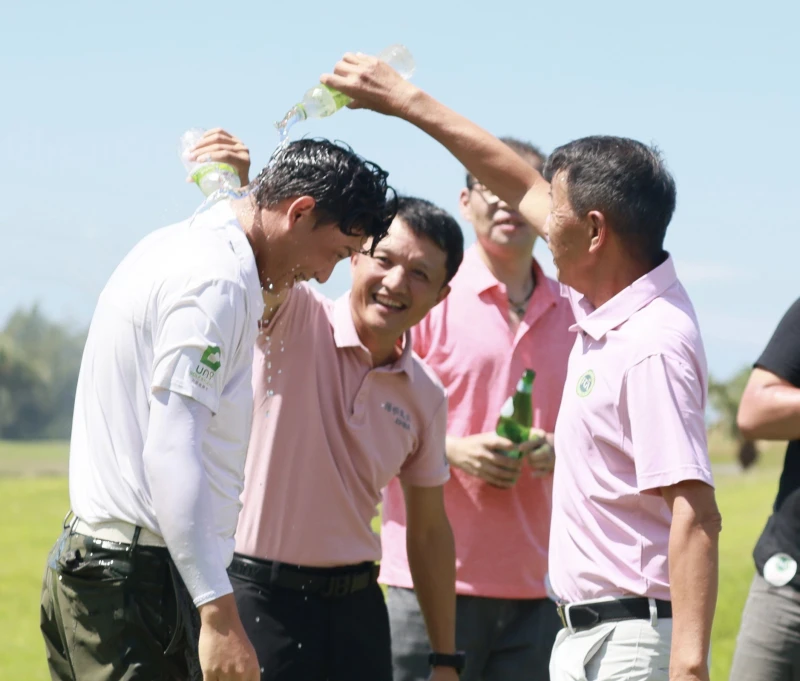 佳運重機械工程股份有限公司董事長特助孫慶旺(中)和陳榮興理事長(右)一起為冠軍得主沙比亞特.馬克灑水慶賀。鍾豐榮攝影S 34750545