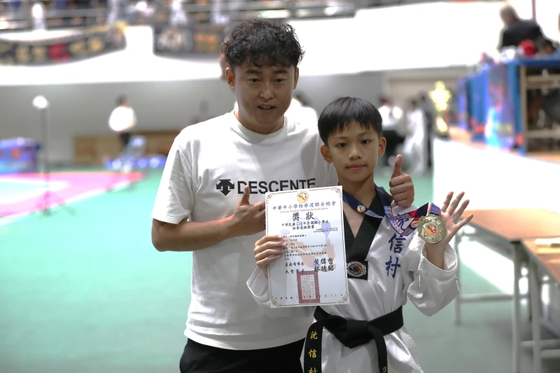 完成4連霸的小霸王沈信村(右)與教練何翰開心合照。大會提供