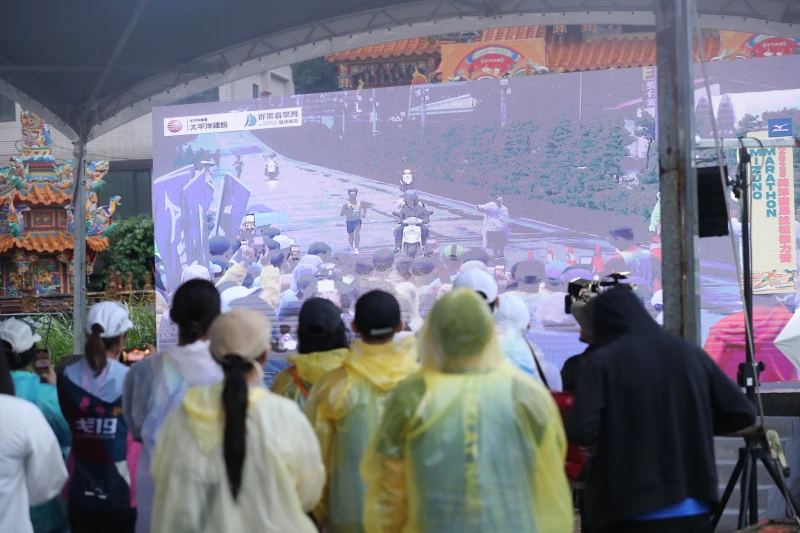 參賽選手躲雨兼看賽事大銀幕直播。詹健全攝
