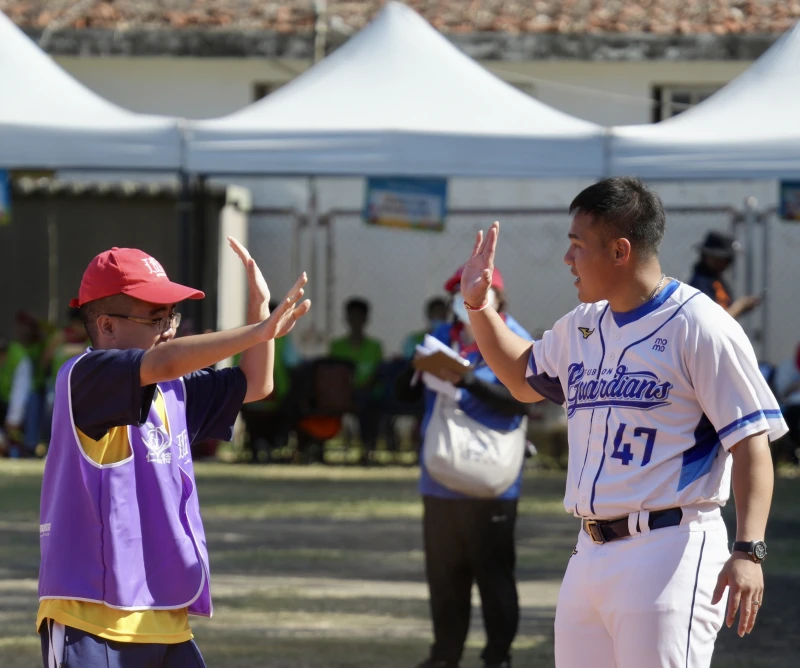 張進德(右)跟選手擊掌主動送上祝福。大會提供
