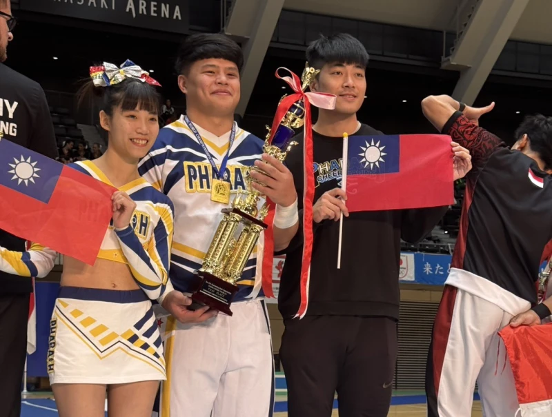 法老競技啦啦隊林宜慶/張庭瑜拿著國旗上台頒獎。中華民國啦啦隊總會提供