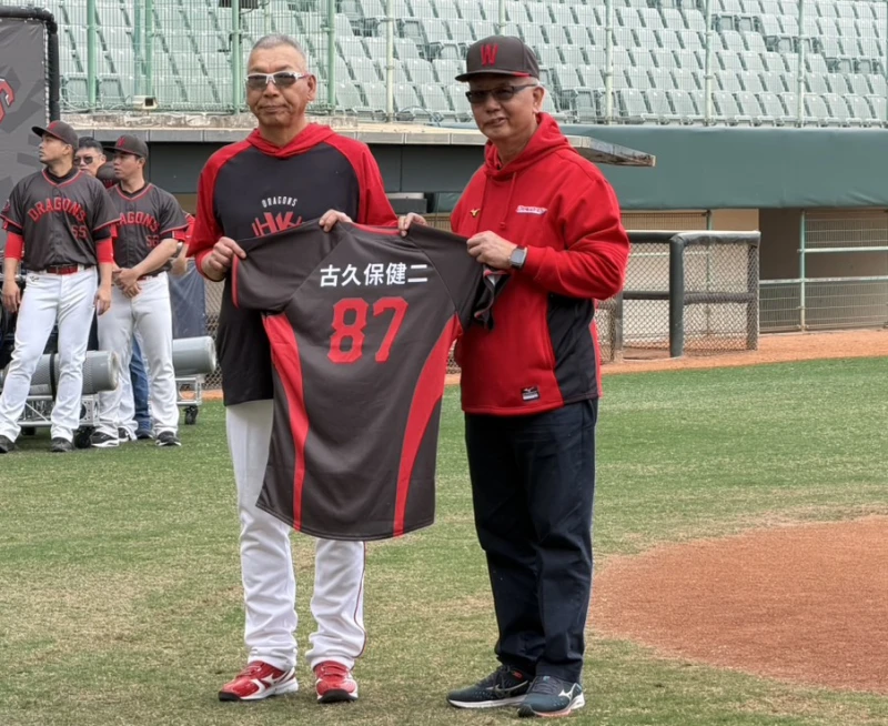 古久保健二（左）從魏應充手中接過味全龍球衣。吳敏欣攝