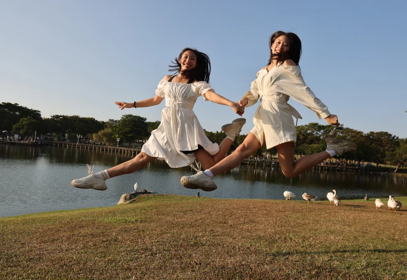 得有空全家出遊，青春無敵的雙胞胎姐妹花，在草地上愉快躍起，留下美好的畫面。特約記者 郭運復攝