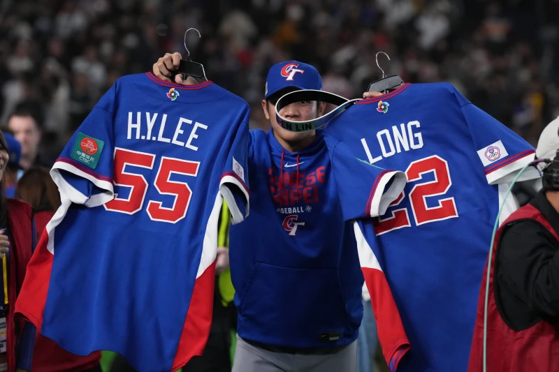 林維恩拿著李灝宇、龍恩球衣。記者劉峻誠攝