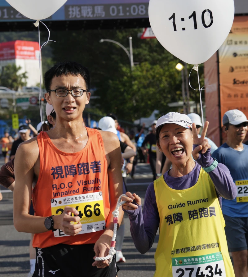 視障跑者陳奕成(左)與陪跑員卓芳亙衝線後合影留念。沈明璁提供